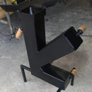 Forno a lenha de metal preto com abraçadeiras de madeira em chão de cimento