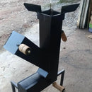 Fogão a lenha metálico preto com alças de madeira, instalado em piso concreto de área externa