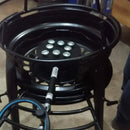 Fogão industrial a gás preto com queimadores circulares, usado em cozinha profissional