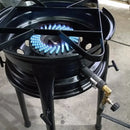 Fogão industrial a gás queimando com chama azul, estrutura metálica preta e controle de regulagem