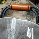 Alça de madeira e metal de ferramenta agrícola com superfícies desgastadas em fundo de chão de oficina