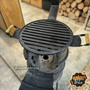 Churrasqueira de tambor com grelha metálica redonda e alças de madeira em área externa